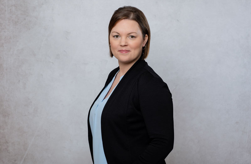 Frau Nicole Westenberger mit kurzen braunen Haaren, einer hellblauen Bluse und einem schwarzen Blazer posiert mit einem leichten L&auml;cheln vor der Kamera.