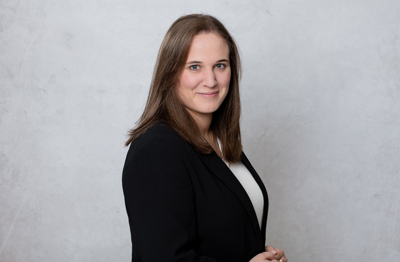 Frau Vivien Horn mit glattem braunem Haar, tr&auml;gt einen schwarzen Blazer und ein wei&szlig;es Oberteil, l&auml;chelt leicht in die Kamera.